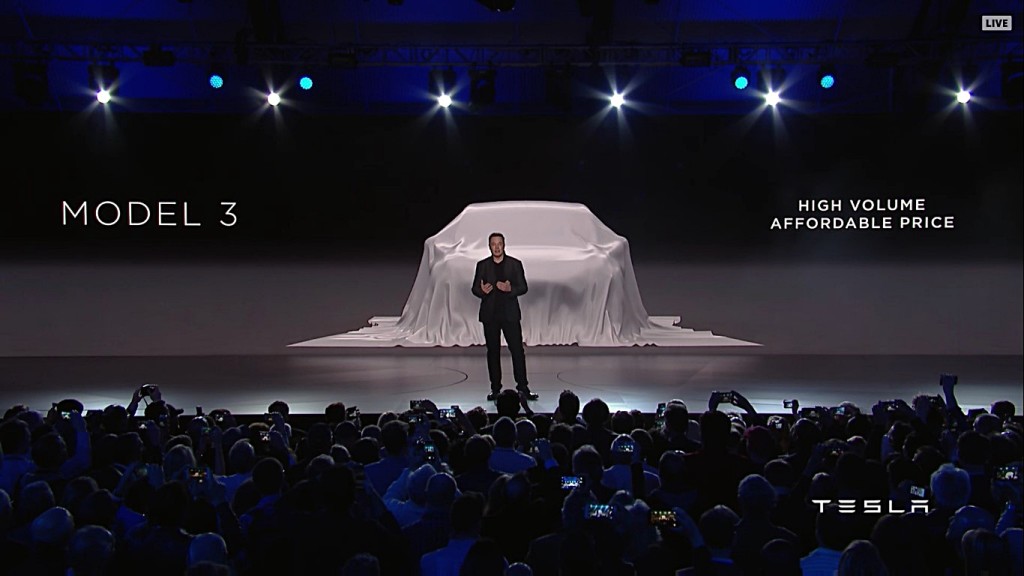 Musk in front of Model 3 draped